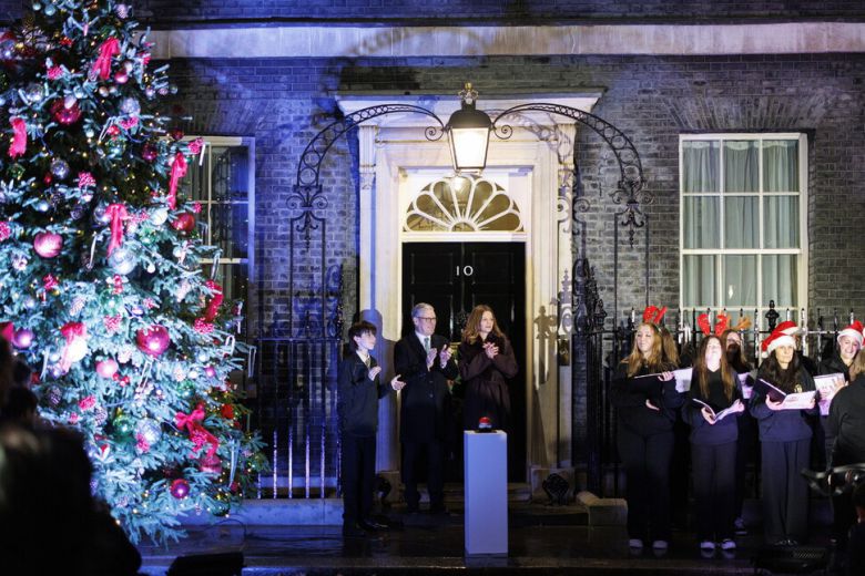 1일(현지시각) 키어 스타머 영국 총리 부부가 런던 다우닝가 10번지 총리실 앞에서 크리스마스 트리 조명을 켠 후 캐럴을 듣고 있다. 런던/EPA 연합뉴스