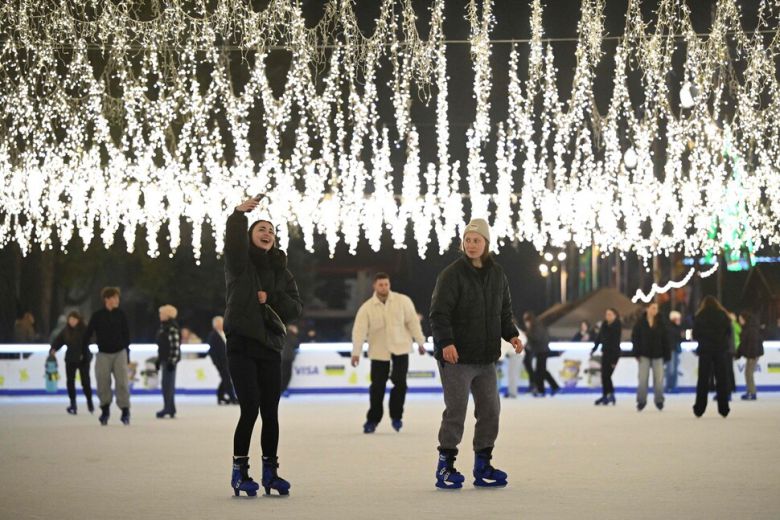 한 우크라이나 여성이 1일(현지시각) 키이우의 크리스마스 마켓 아이스링크에서 스케이트를 타며 셀카 사진을 찍고 있다. 키이우/AFP 연합뉴스