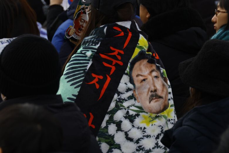 지난 1월25일 오후 ‘윤석열 즉각퇴진·사회대개혁 비상행동’ 주최로 열린 퇴진 촉구 집회에서 참가자들이 내란 피의자 윤석열 전 대통령을 히틀러처럼 풍자한 천을 두르고 있다. 윤운식 선임기자 yws@hani.co.kr