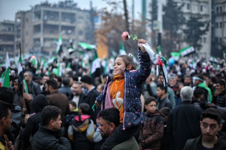 8일(현지시각) 시리아 이들립에서 해방기념일을 맞아 열린 기념 행사에서 한 소녀가 아빠의 어깨 위에 앉아 기뻐하고 있다. EPA 연합뉴스