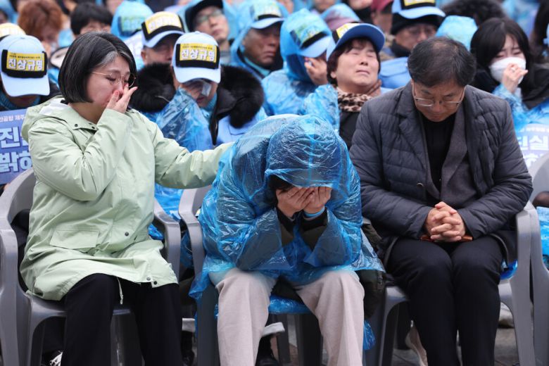20일 오후 서울 종로구 보신각 광장에서 열린 1229 무안공항 제주항공 여객기 참사 1주기 서울시민추모대회에서 유가족 김영헌씨가 유가족 편지를 낭독하는 동안 김유진 유가족 대표(가운데)가 흐느끼고 있다. 김태형 기자