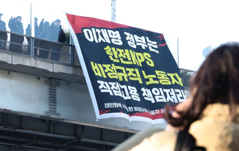 태안화력 고 김충현 비정규직 노동자 사망사고 대책위원회 관계자들이 7일 오전 서울 중구 서울로7017에서 이재명 정부에 한전케이피에스(KPS) 직접고용을 촉구하며 펼침막을 내거는 기습시위를 벌이며 구호를 외치고 있다. 최현수 기자 emd@hani.co.kr