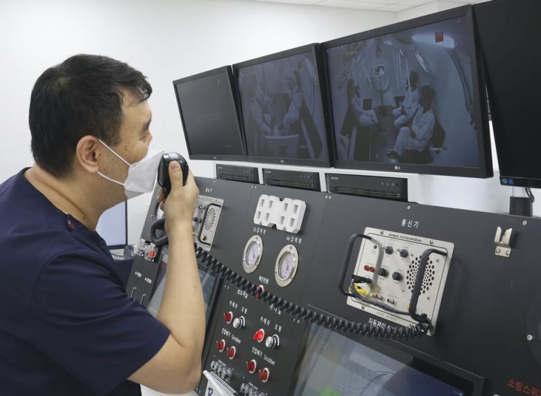 김련 전담간호사가 고압산소챔버에서 치료를 받는 환자들과 이야기를 하고 있다.