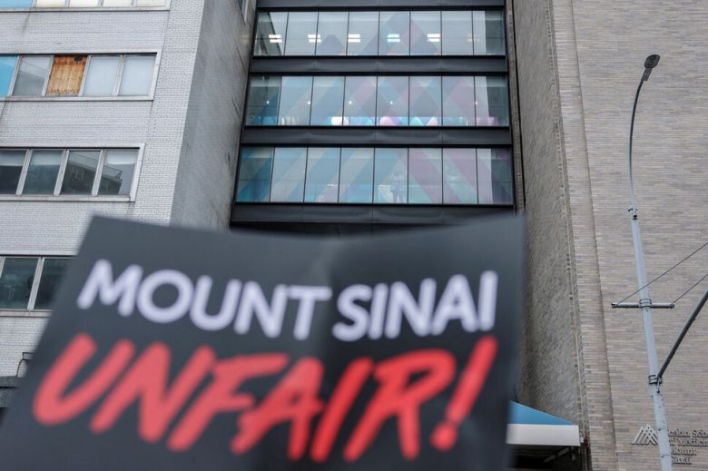 미국 뉴욕 맨해튼 마운트 시나이 병원 직원들이 14일(현지시각) 건물 들머리에 모여있는 시위대를 바라보고 있다. 뉴욕/로이터 연합뉴스