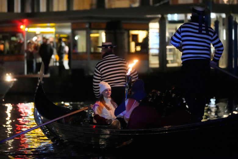 성화 주자가 22일 이탈리아 베네치아 그랑카날에서 곤돌라를 타고 이동하고 있다. 베네치아/AP 연합뉴스