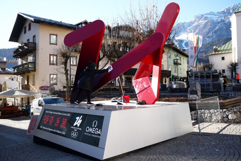 21일 한 여성이 이탈리아 코리티나 담페초에서 카운트다운 화면이 함께 있는 이번 겨울올림픽 로고를 닦고 있다. 코르티나 담페초/로이터 연합뉴스