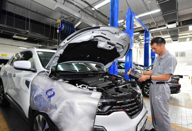 한 완성차 서비스 센터 직원이 침수된 차량을 점검하고 있다. 연합뉴스