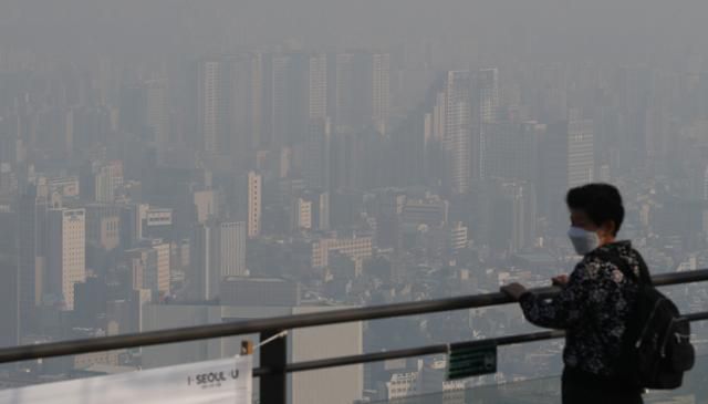 서울 지역 미세먼지가 '나쁨'을 보인 15일 한 시민이 서울 중구 남산에서 뿌연 서울 시내를 내려다 보고 있다. 뉴스1