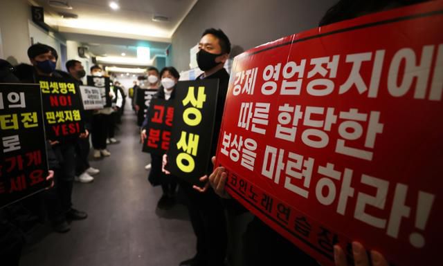 8일 자정 서울 서대문구의 한 코인노래방에서 신종 코로나바이러스 감염증(코로나19) 대응 전국자영업자 비상대책위 주최로 열린 방역기준 불복 개점 시위에서 참석자들이 정상 영업을 촉구하며 구호를 외치고 있다. 이날 시위에서 코인노래방 업주들은 방역 당국의 획일적인 영업시간 제한 폐지, 형평성 있는 방역기준 조정과 대책 마련을 촉구했다. 연합뉴스