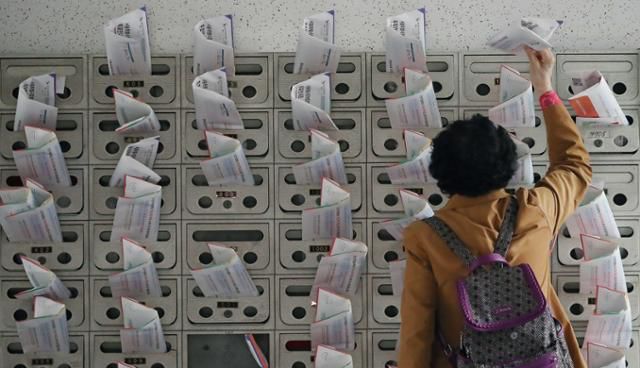 4.7 서울시장 보궐선거를 열흘 앞둔 지난달 28일 서울 용산구의 한 아파트 주민이 우편함에서 선거공보물을 챙기고 있다. 뉴스1