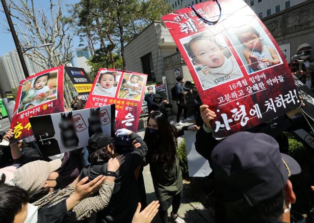 '정인이 사건(생후 16개월 입양아 학대사망 사건)' 결심공판이 열린 14일 오후 서울 양천구 서울남부지법 입구에서 시민들이 양모가 탑승한 것으로 보이는 호송차를 향해 손피켓을 들고 항의하고 있다. 뉴시스