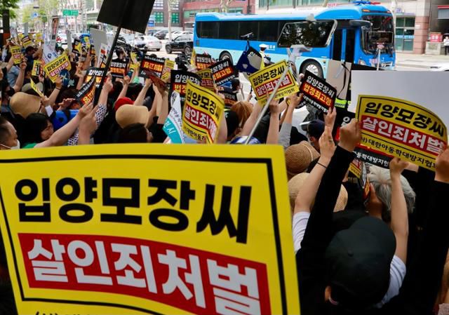 '정인이' 양부모의 1심 선고공판이 열린 14일 서울 양천구 서울남부지방법원 앞에 모인 시민들이 호송차가 지나가자 피켓을 들고 강력한 처벌을 촉구하고 있다. 뉴스1