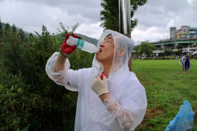최재형 전 감사원장이 17일 오전 부산 해운대구 석대사거리 동천교 인근에서 국민의힘 김미애 의원과 국민의힘 해운대구을 당원협의회가 마련한 환경미화 봉사활동을 하던 중 물을 마시고 있다. 김미애 의원실 제공