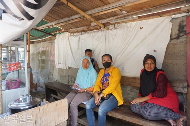 플루이트 주민들이 바닷물을 막기 위한 둑에 기대 마을에 얽힌 얘기를 하고 있다. 자카르타=고찬유 특파원