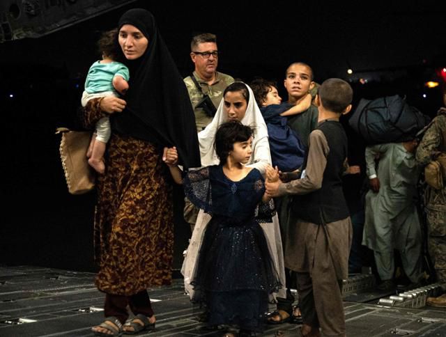 이슬람 무장조직 탈레반이 장악한 아프가니스탄에서 탈출한 사람들이 19일 미국 수송기를 타고 임시 수용 시설로 가고 있다. 미군은 이 사진이 어느 나라의 어떤 기지인지는 밝히지 않았다. AFP 연합뉴스