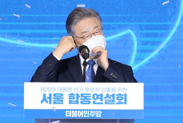 [더불어민주당 제20대 대통령 후보에 선출된 이재명 후보가 10일 서울 송파구 올림픽공원 핸드볼경기장에서 열린 서울 합동연설회에서 수락 연설 전 마스크를 벗고 있다. 뉴시스