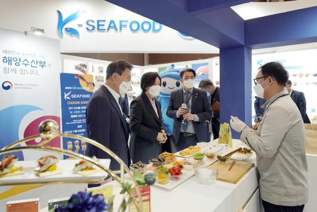 문재인 대통령과 김정숙 여사가 11월 11일 서울 삼성동 코엑스 그랜드볼룸에서 열린 ‘2021 K-박람회’ 해양수산부 홍보관을 찾아 김을 사용한 요리 시연을 지켜보고 있다. 뉴시스