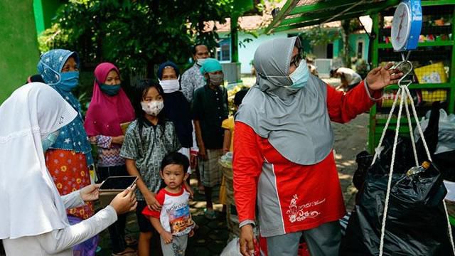인도네시아 시민단체 림바 푸스타카의 설립자 라덴 로로 헨다르티씨가 주민들에게 책을 빌려주기 위해 쓰레기 무게를 재고 있다. 템포닷코 캡처