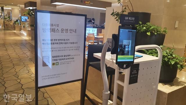 서울 중구 롯데백화점 본점에 10일 방역패스 의무화를 알리는 안내문과 QR코드 체크기가 비치돼 있다. 윤한슬 기자