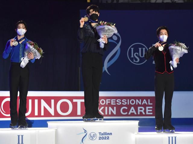 차준환(가운데)이 23일(현지시간) 에스토니아 탈린의 톤디라바 아이스 홀에서 열린 2022 국제빙상연맹(ISU) 4대륙선수권대회에서 우승한 후 시상대에 올라 금메달을 들고 포즈를 취하고 있다. 탈린=AP/뉴시스