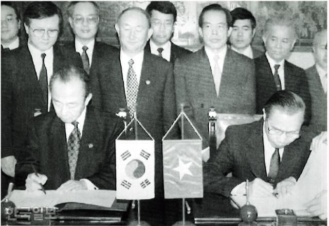 1992년 12월 22일 베트남의 수도 하노이를 방문한 김상옥(왼쪽) 한국 외무장관이 구웬만캄 베트남 외무장관과 함께 정부 영빈관에서 한국과 베트남의 수교에 관한 공동성명에 서명하고 있다. 한국일보 자료사진