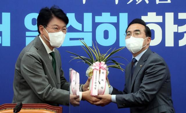 박홍근(오른쪽) 신임 더불어민주당 원내대표가 25일 오전 국회에서 장제원 대통령 당선인 비서실장에게 축하 난을 받고 있다. 오대근 기자