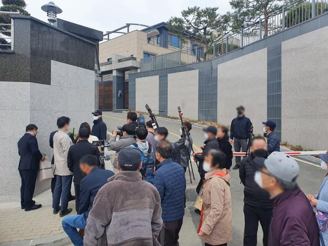 박성민 국민의힘 의원(대표비서실장)이 25일 오후 1시 25분쯤 대구 달성군 유가읍 쌍계리 박근혜 전 대통령 사저 앞에서 이준석 대표가 보낸 난을 들고 있는 가운데 지지자들의 비난을 받고 있다. 류수현 기자