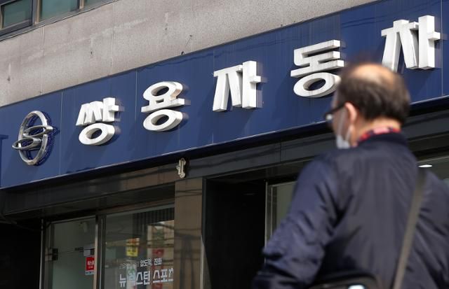 에디슨모터스의 쌍용차 인수계약이 무산될 위기에 놓인 27일 오전 서울 시내 한 쌍용차 판매점 앞에서 시민이 이동하고 있다. 이날 법조계에 따르면 에디슨모터스 컨소시엄은 인수대금 잔금 납입 기한인 지난 25일까지 잔금을 지급하지 못했다고 밝혔다.