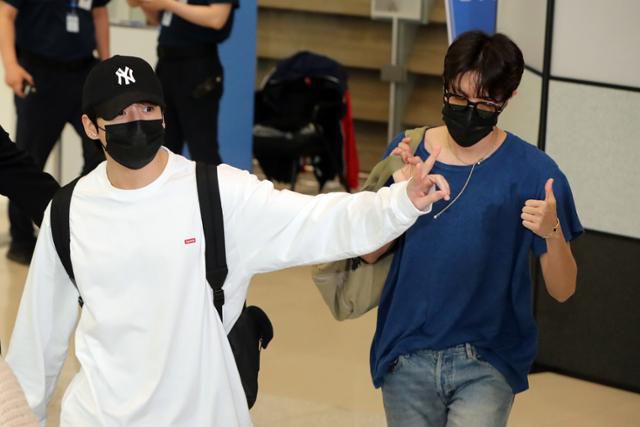 방탄소년단 멤버 정국(왼쪽)과 제이홉이 2일 인천국제공항으로 귀국하며 팬들을 향해 손을 흔들어 인사하고 있다. 영종도=연합뉴스