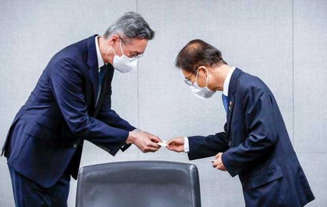 이정식(오른쪽) 고용노동부 장관이 3일 오전 서울 용산구 크라운제과에서 열린 임금피크제 운영사업장 현장방문 간담회에서 윤석빈 크라운제과 대표이사와 명함을 교환하고 있다. 뉴시스