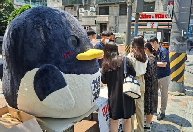 꽃비씨와 영업사원들이 함께 만든 '처음처럼' 야외 판촉 현장. '처음처럼'의 마스코트인 까치 캐릭터 인형은 꽃비씨가 직접 제작했다. 사진 속 까만 원피스를 입은 여성이 꽃비씨. 유꽃비 제공