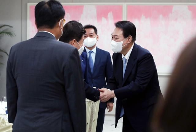 윤석열 대통령이 19일 서울 용산 대통령실 청사에서 열린 신임 국회의장단 초청 만찬에 참석하며 김진표 국회의장과 악수하고 있다. 뉴시스