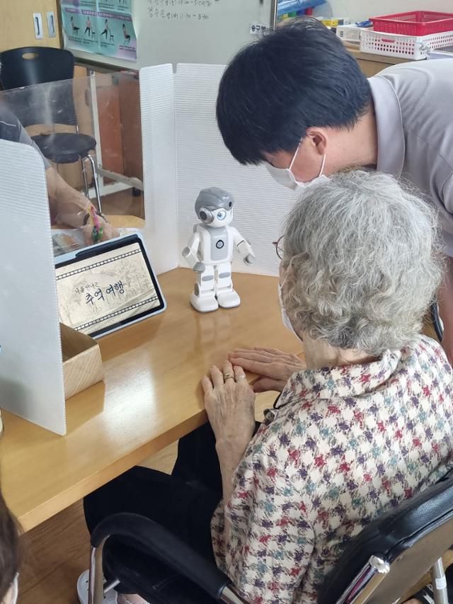 지난달 31일 서울 종로구청 내 주민센터에서 한 할머니(왼쪽)가 구청 직원으로부터 반려로봇 사용법을 교육받고 있다. 종로구 제공