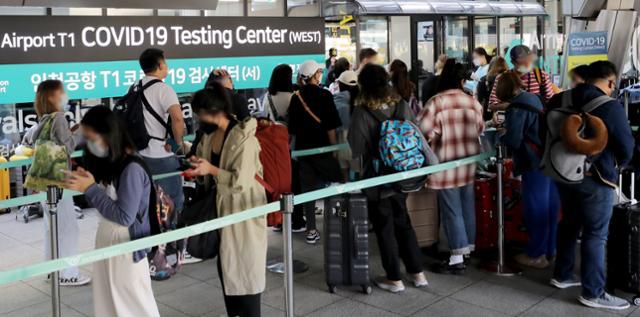 해외 입국자들이 21일 인천국제공항 1터미널에서 신종 코로나바이러스 감염증(코로나19) 검사를 받기 위해 검사센터에 줄 서 있다. 뉴스1