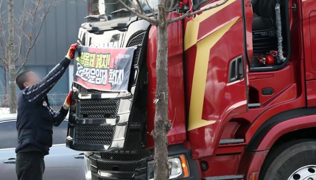 9일 화물연대의 파업 철회 조합원 찬반 투표 결과 현장 복귀가 결정되자 충남 당진시 현대글로비스 앞에서 파업 농성을 하던 한 조합원이 화물차에 부착한 플래카드를 떼고 있다. 당진=뉴스1