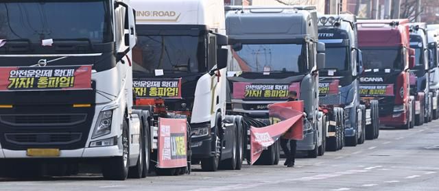 화물연대가 총파업을 철회한 9일 오후 경기도 의왕시 내륙컨테이너기지(ICD)앞 도로에 주차된 화물차에서 한 조합원이 현수막을 철거하고 있다. 의왕=뉴시스