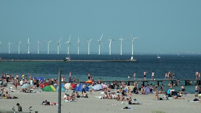 지난 7월 덴마크 코펜하겐의 아마게르 수변공원에 모인 피서객들 너머로 미들그룬덴 해상풍력발전단지가 보인다. 코펜하겐=이수연PD