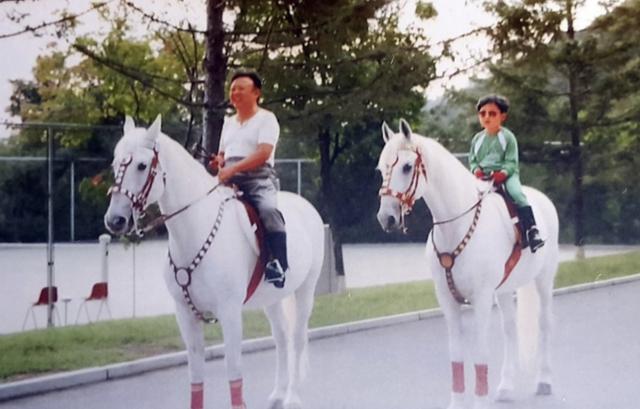김정은 북한 국무위원장이 어린 시절 아버지 김정일 국방위원장과 평양 인근에서 승마를 즐기는 모습. 이 사진은 평양 인근의 한 혁명 사적관에 걸린 것으로 알려졌다. 연합뉴스