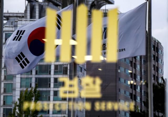 한 시민단체가 KT 구현모 대표와 윤경모 사장을 일감 몰아주기 등으로 검찰에 고발하면서 관련 수사가 이뤄지고 있다. 서울중앙지검 출입구 검찰로고 뒤로 태극기가 바람에 흔들리는 모습. 사진=류효진 기자
