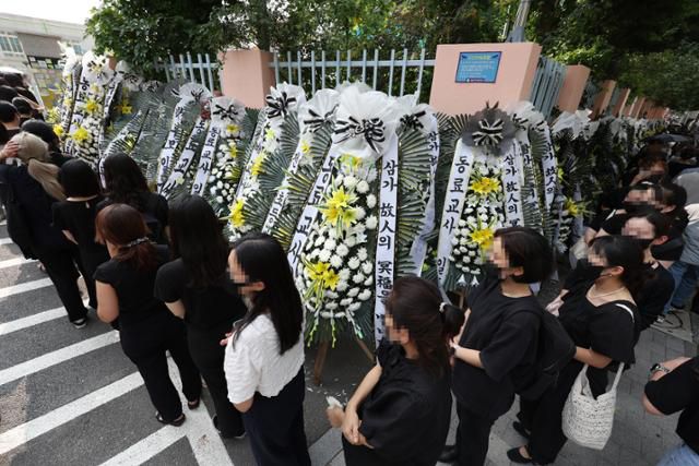 20일 오후 서울 서초구 한 초등학교 앞에 교내에서 극단적 선택을 한 교사를 애도하려는 추모객들이 길게 줄지어 서 있다. 연합뉴스