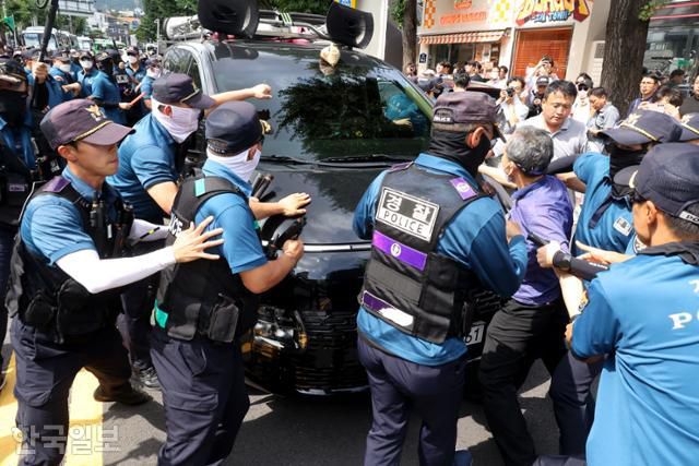 이태원 참사 유족과 시민대책위 관계자들이 25일 오후 서울 종로구 헌법재판소 앞에서 이상민 행정안전부 장관 탄핵심판 기각 결정을 규탄하는 기자회견 도중 보수단체 회원이 차량에 설치된 확성기로 유족을 폄훼하는 발언을 하자 차량으로 달려들고 있다. 최주연 기자