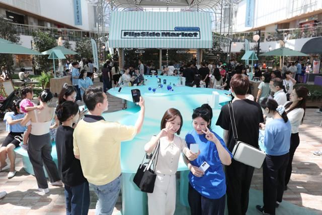 삼성전자가 서울 여의도 더현대서울에서 운영하는 갤럭시 스튜디오 '플립 사이드 마켓'에서 방문객이 '갤럭시Z폴드5'와 '갤럭시Z플립5' 등 신제품을 체험하며 사진을 찍고 있다. 삼성전자 제공