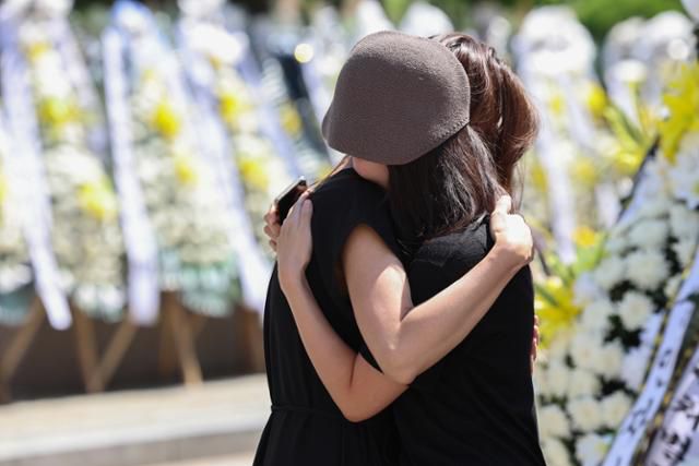 지난달 31일 극단적 선택으로 숨진 초등교사가 근무했던 서울 양천구 소재 초등학교 앞에 마련된 추모공간에서 2일 추모객들이 끌어안고 서로를 위로하고 있다. 연합뉴스