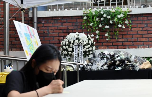 3일 서울 서초구 서이초등학교 1학년 6반 교실 외벽에 설치된 추모공간을 찾은 한 시민이 된 극단적 선택을 한 교사를 추모하는 메시지를 적고 있다. 뉴스1
