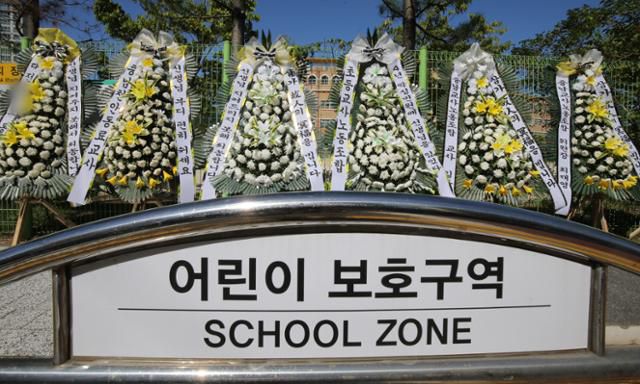 학부모들의 아동학대 신고와 악성민원에 고통받다가 지난 7일 사망한 대전 교사가 재직했던 대전 유성구의 한 초등학교 정문에 8일 고인을 추모하는 근조화환이 놓여 있다. 뉴스1