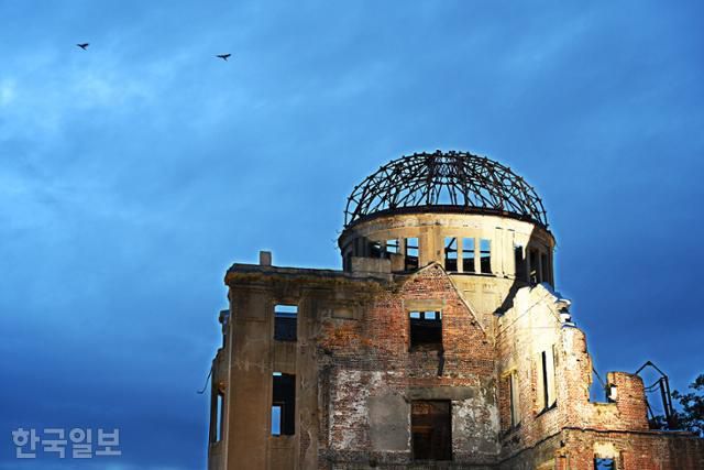 히로시마 평화기념공원의 상징물 원폭돔 위로 비둘기가 날고 있다. 1915년 물산진열관으로 세운 건물이다.