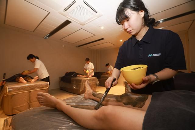 해양치유센터를 찾은 사전 방문자들이 머드 테라피 프로그램을 체험하고 있다. 완도군 제공