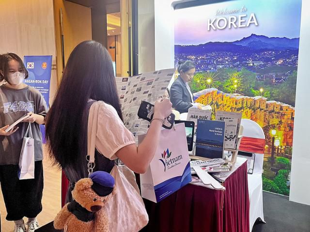 1일 베트남 하노이에서 열린 한국-아세안의 날 사진전에서 한 시민이 한국 여행지가 담긴 홍보자료를 살펴보고 있다. 하노이=허경주 특파원