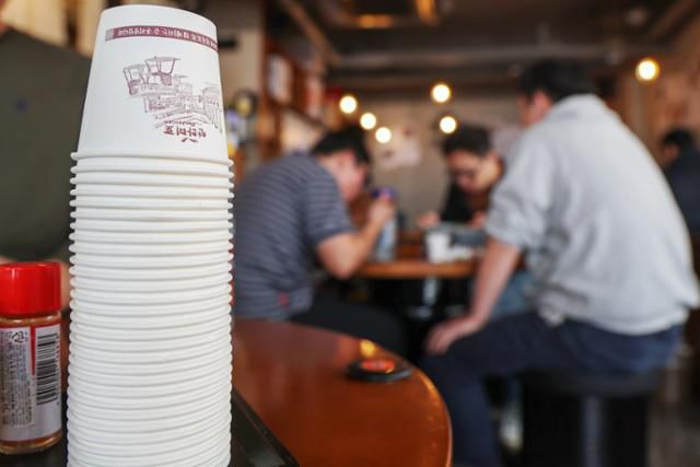 정부가 종이컵 사용 규제 정책 완화를 발표한 지난 11월 7일 서울 시내 한 식당 테이블에 종이컵이 높이 쌓아올려져 있다. 뉴스1