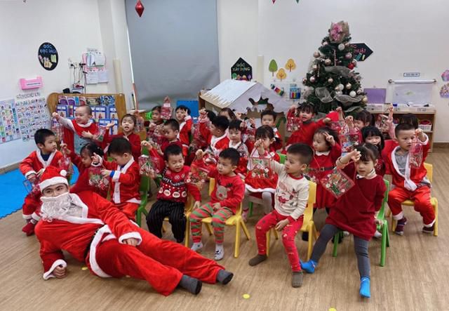 지난해 12월 베트남 하노이의 한 유치원에서 산타 의상을 입은 남성이 아이들과 기념사진을 찍고 있다. 까오티민 제공